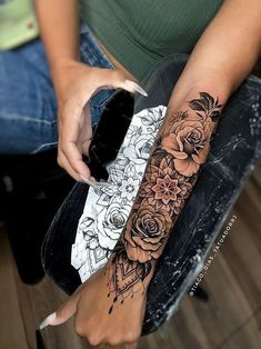 a woman is sitting on a chair with her arm tattooing roses and an ice cream cone