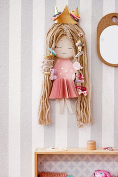 a doll is hanging on the wall next to a shelf with toys and other items