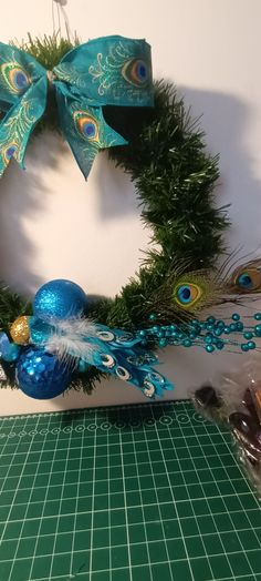 a christmas wreath with peacock feathers and ornaments