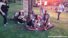 a group of young women sitting on top of a grass covered field next to each other