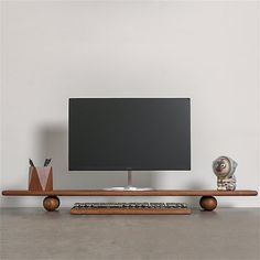 a flat screen tv sitting on top of a wooden shelf