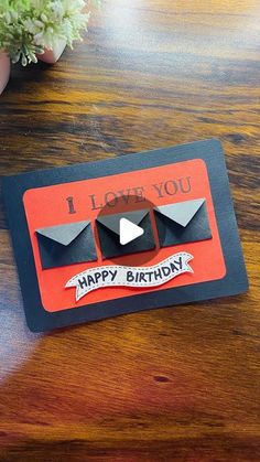 a happy birthday card sitting on top of a wooden table