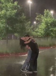 two people are hugging in the rain on a skateboard and one person is holding his head