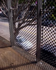 a metal fence that is next to a tree