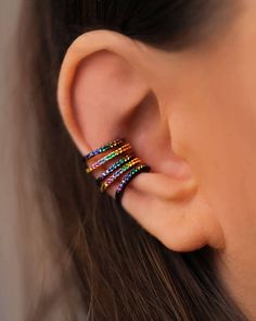 a woman's ear is adorned with multicolored beads