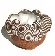 a brown and white striped basket sitting on top of a table