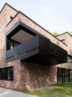 a brick building with black balconies on the top and bottom floor is shown