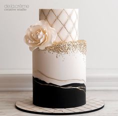 a white and black cake with gold decorations