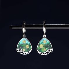 100% handmade sterling silver earrings, covered with hot cloisonné enamel. Cloisonné  is an ancient technique for decorating metalwork objects with colored material held in place or separated by metal strips or wire, normally of gold or silver. This process is quite laborious, because all the details require hand processing. Georgian cloisonné enamel counts more than 1200 years of history.  Our handmade pendants, earrings, brooches are vibrant with colour and compliment any outfit, prefered for daily wear or a special occasion. Materials: Sterling Silver, Fine Silver, Cloisonne enamel Weight - 6 gr (approx) Drop Lenght - 2.2 cm; 0.9 inches  Lenght - 3.5 cm; 1.4 inches Width - 1.8 cm; 0.7 inches  Matching Pendant: https://www.etsy.com/listing/1311367379/georgian-cloisonne-enamel-pendant?cli Green Dangle Earrings, Cloisonne Earrings, Cloisonne Enamel, Jewelry Sterling Silver, Metal Clay, Jewelry Tools, Enamel Jewelry, Silver Foil, Handmade Sterling Silver