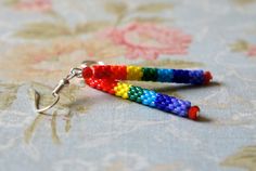 two pairs of colorful beaded earrings sitting on top of a flowered table cloth