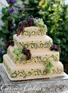 a three tiered cake with grapes on top