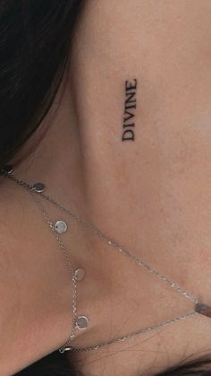 the back of a woman's neck with a tattoo saying dance on her chest