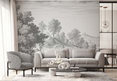 a living room with a couch, chair and table in front of a wall mural