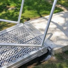 there is a metal step that has been placed on the ground with grass in the background