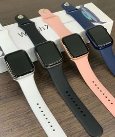 four apple watch bands sitting on top of each other in front of an open box