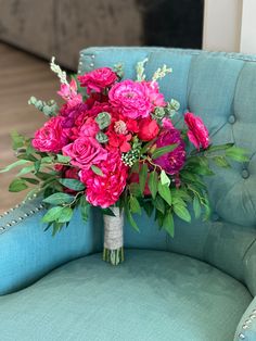 a bouquet of pink flowers sitting on top of a blue chair