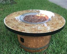 a fire pit sitting in the grass next to a tree