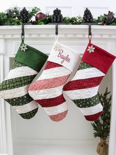 three christmas stockings hanging from a mantel