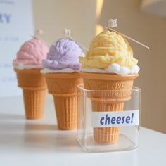 three ice cream cones sitting on top of a table