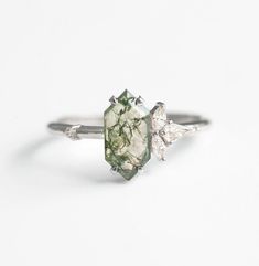 Radiating with natural elegance, the Moss Agate Engagement Ring with Diamond Moss captivates with its enchanting beauty. At its heart lies a captivating moss agate, a picturesque portrayal of nature's serene landscapes, adorned with delicate diamonds that sparkle like dewdrops on a lush morning meadow. This ring is more than a symbol of commitment; it's a timeless expression of love and reverence for the earth's wonders. Step into a realm of unrivaled craftsmanship and exclusivity with our signature line of Moss Agate jewelry. As pioneers in the field, we meticulously design each piece, sculpting the rarest geometric Moss Agate into one-of-a-kind creations. With unwavering commitment to excellence, we set the highest standards in production, ensuring unparalleled quality and authenticity t Nature-inspired Wedding Rings With Natural Stones, Elegant Moss Agate Rings With Natural Inclusions, Nature-inspired Moss Agate Jewelry With Natural Inclusions, Nature-inspired Agate Rings With Natural Inclusions, Elegant Moss Agate Ring With Natural Stones, Unique Moss Agate Ring For Wedding, Nature-inspired Diamond Rings With Gemstones, Nature-inspired Moss Agate Jewelry For Anniversary, Unique Moss Agate Wedding Ring