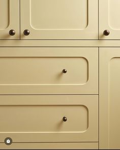 a beige cabinet with knobs and handles