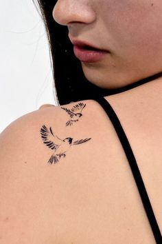 a woman with a bird tattoo on her shoulder