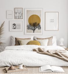 a bedroom with white walls and pictures on the wall above the bed, along with a wicker coffee table