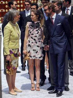 two women and one man standing next to each other in front of a group of people