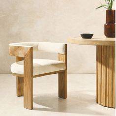 a wooden chair next to a table with a potted plant on it