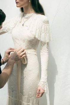 a woman in a white dress is being photographed