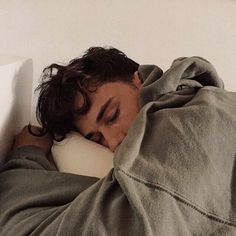 a man sleeping in bed with his head on the pillow