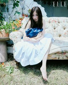 a woman sitting on a couch in the grass