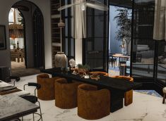 a living room filled with lots of furniture next to a large glass window covered patio