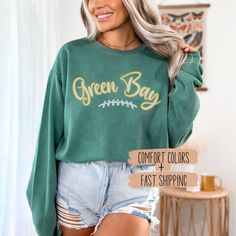 Check out our Green Bay football women's apparel, featuring a Greenbay football shirt perfect for game day. This crewneck is a great team spirit wear idea, making it the ideal football gameday t-shirt for any girl. ✨𝐏𝐑𝐎𝐃𝐔𝐂𝐓 𝐃𝐄𝐓𝐀𝐈𝐋𝐒✨ ☆ Comfort Colors 1566 unisex sweatshirt ☆ 80% ring-spun cotton, 20% polyester ☆ 1x1 ribbed collar, cuffs, and bottom hem for stretch and a well-fitted garment ☆ Necktape: twill tape stabilizes the neck seam for comfort and prevents stretching ✨𝐂𝐀𝐑𝐄 Green Bay Packers Outfits Woman, Green Bay Packers Clothing, Football Women, Football Sweatshirt, Spirit Wear, Football Shirt, Green Bay, Team Spirit, Twill Tape