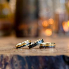 two wedding rings sitting on top of a wooden table