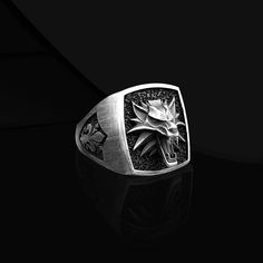 Wild White Wolf Ring Introducing the Wild White Wolf Men's Silver Ring, a stunning piece of craftsmanship that will leave your loved one in awe. This exquisite handmade wolf silver men's ring is the perfect gift for your boyfriend. Expertly engraved with a magnificent white wolf design, this ring symbolizes strength, loyalty, and resilience. The intricate detailing brings the majestic creature to life, making it a truly remarkable piece. Whether it's for a special occasion or a heartfelt Christmas gift, this Wolf Engraving Ring is sure to make a lasting impression. Show your admiration for the wild spirit with this extraordinary jewelry piece. Product Code: FRYKRT102 Product Name: Wild White Wolf Ring Metal: Handmade oxidized 925 Sterling Silver Ring (Can also be produced in 14/18/22 carat Wolf Ring, Mens Gemstone Rings, Extraordinary Jewelry, 22 Carat Gold, Gifts For Your Boyfriend, Mens Silver Rings, Silver Man, Engraved Rings, Signet Ring