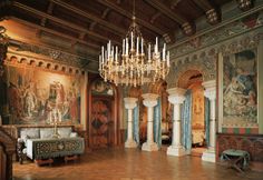 an ornate room with chandeliers and paintings on the walls