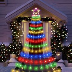 a lighted christmas tree in front of a house