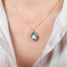 This Moonstone pendant shimmers with a swirling, blue iridescence. This one-of-a-kind gemstone is set in a meticulously hand-crafted gold setting with braided gold and granulated prongs. It’s strung on an 18k yellow gold chain. Technical Details Metal: 18k yellow goldMoonstone: 8.27 cts. Pendant Size (not including bail): 17mm x 13.5mmChain: can be worn at 16" and 18"Closure: lobster claspHandmade in New YorkStyle # N-3476-MO Gold Drop Necklace With Gemstone Accents, Gold Moonstone Necklace With Briolette Shape, Gold Moonstone Briolette Necklace, Gold Necklace With Moonstone Briolette, Gold Teardrop Cabochon Jewelry, Artisan Yellow Gold Teardrop Jewelry, Gold Cabochon Teardrop Pendant Jewelry, Gold Teardrop Necklace With Gemstone Accents, Handmade Yellow Gold Teardrop Pendant Jewelry