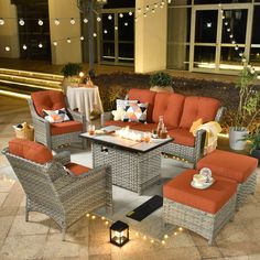 an outdoor seating area with orange cushions and lights