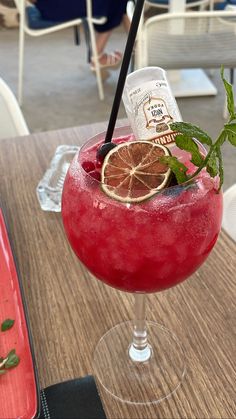 a red drink sitting on top of a wooden table