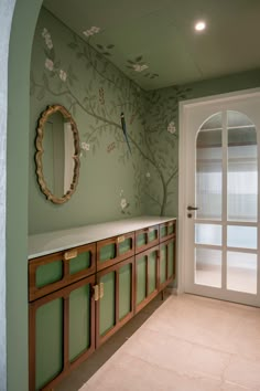 a bathroom with green walls and floral wallpaper on the walls, along with wooden cabinets