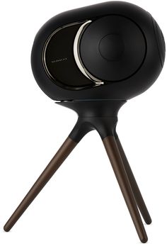 a black speaker sitting on top of a wooden tripod