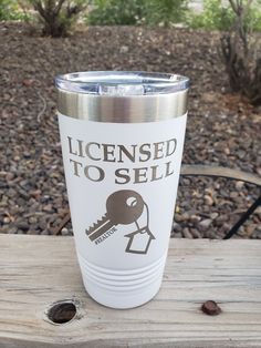 a stainless steel tumbler with the words license to sell on it sitting on a wooden table