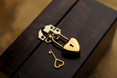 a pair of scissors and a heart shaped lock on top of a piece of wood