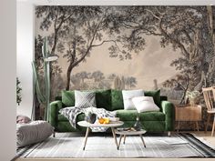 a living room with a green couch and wallpaper that has trees in the background