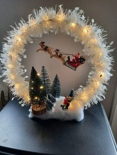 a christmas wreath with santa and his sleigh in the middle on top of a table