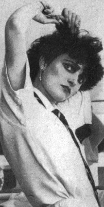 a black and white photo of a woman with her hair in the air, wearing a shirt and tie