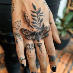 a woman's hand with tattoos on it and a butterfly tattooed on the palm