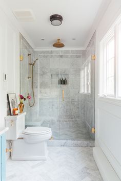 a white toilet sitting in a bathroom next to a walk in shower